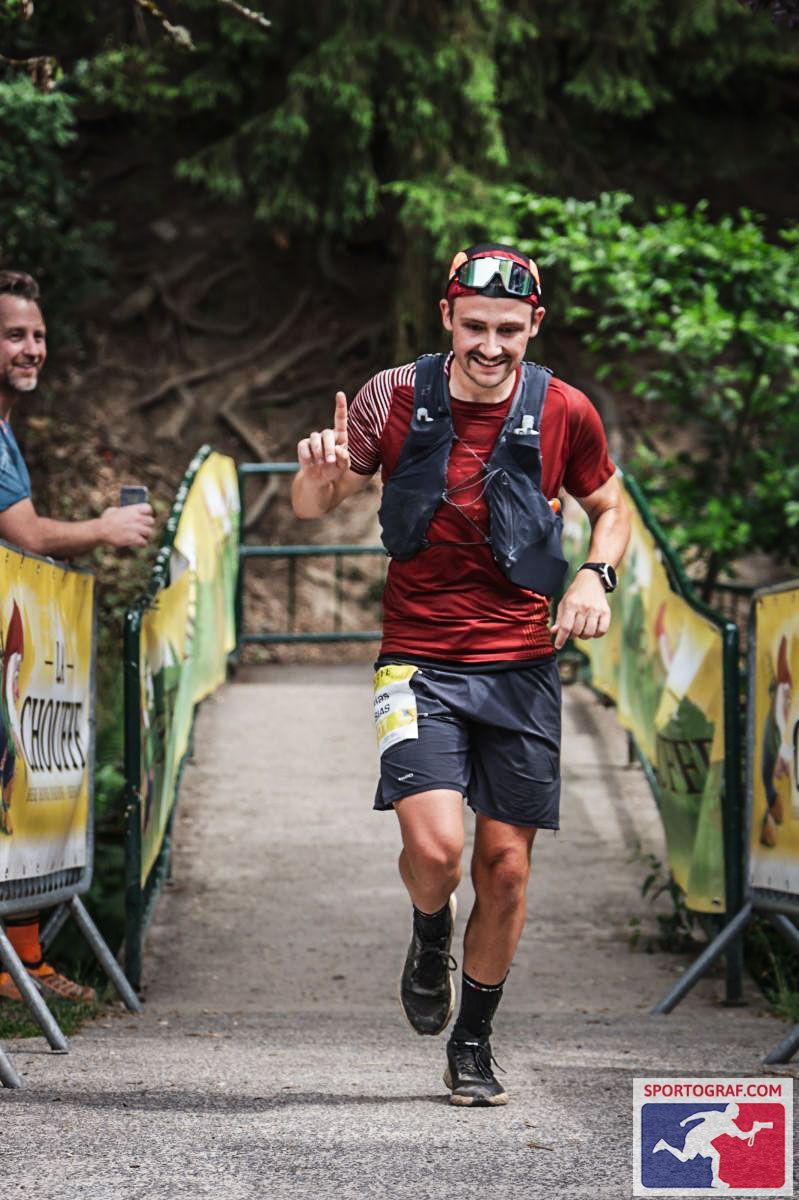 Nicolas en course, doigt levé, à l'arrivée d'un trail en forêt